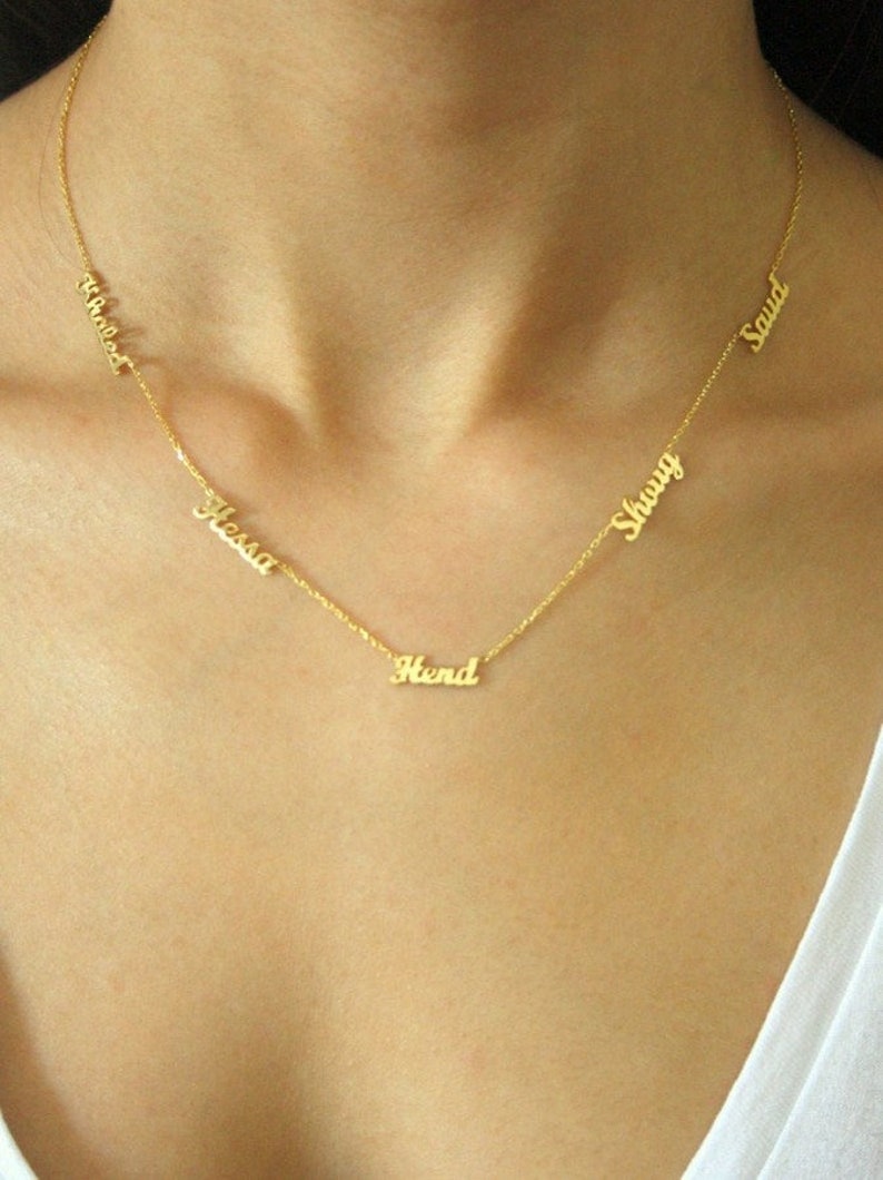 May include: Gold necklace with five name tags, including "Hend", "Hessa", "Shouv", "Saud", and "Ahemed".