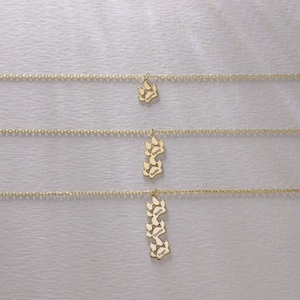 May include: Three gold necklaces with paw print charms. The charms are engraved with the names Sophia, Daisy, Sadie, Bella, Simba, and Tiger.