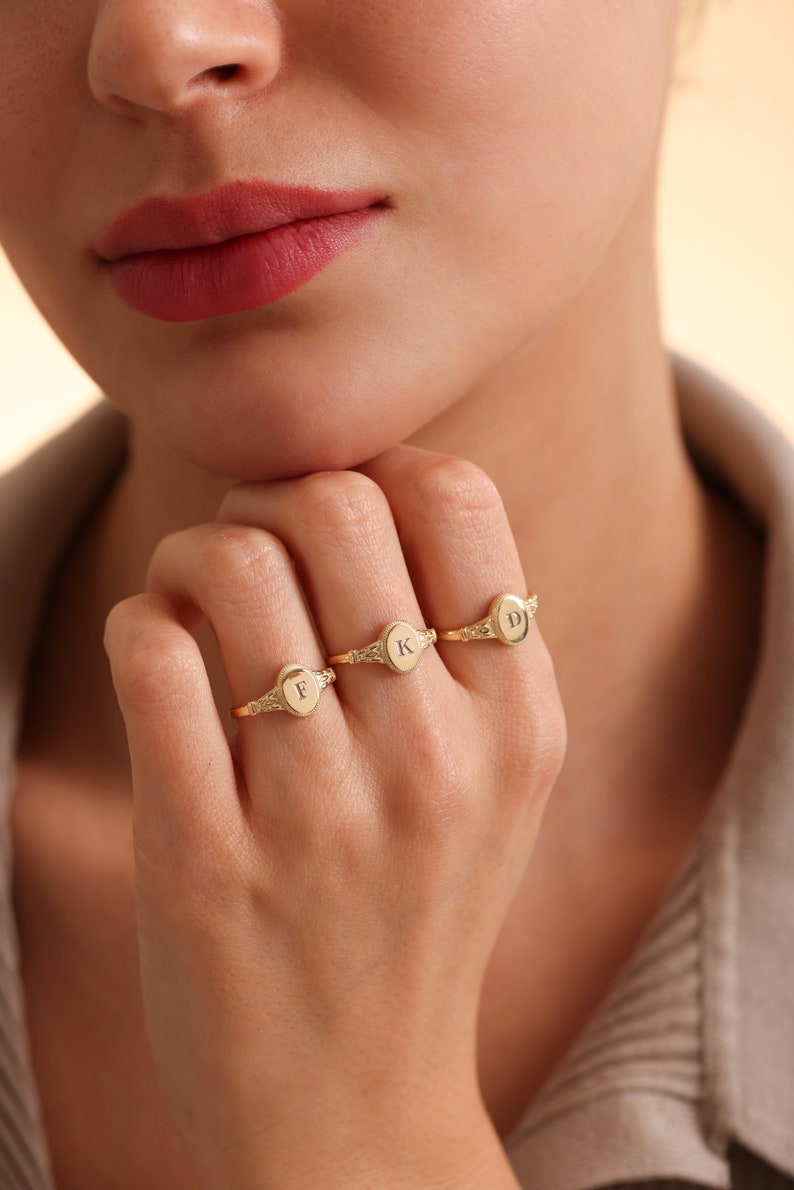May include: Three gold signet rings with the letters F, K, and D engraved on the oval tops.