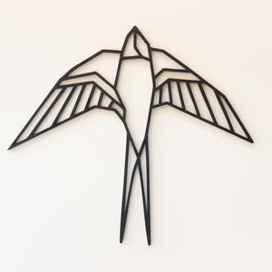 May include: Black metal geometric swallow wall decor. The swallow is in flight with its wings spread wide.