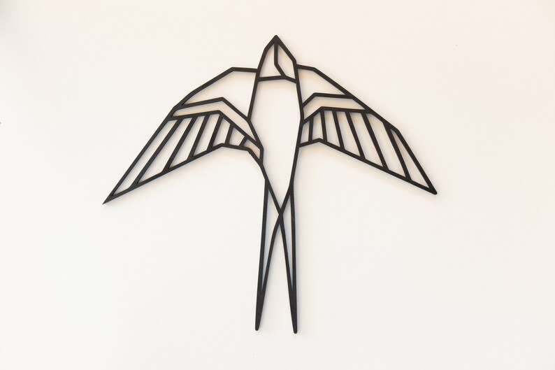 May include: Black metal geometric swallow wall decor. The swallow is in flight with its wings spread wide.