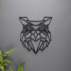 May include: Black geometric owl wall decor made of wood. The owl is in a modern style with a geometric design.