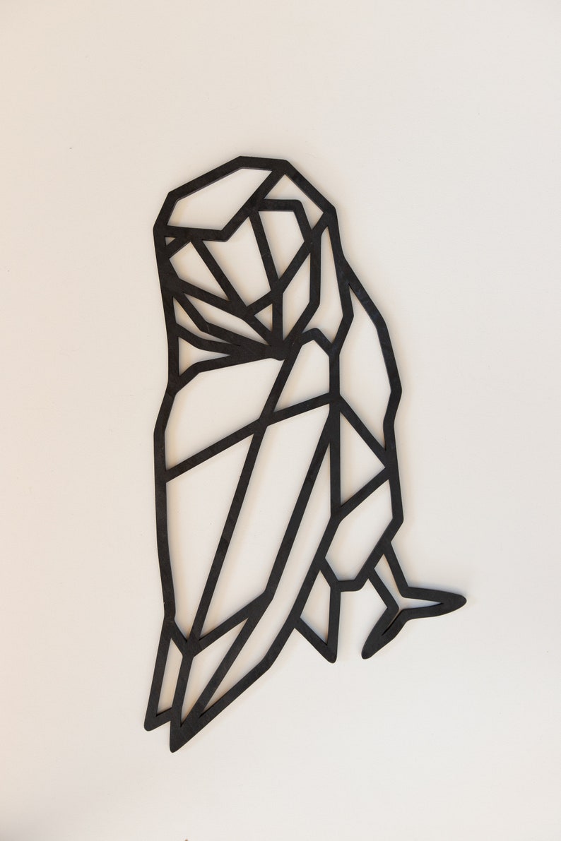 May include: Black geometric owl wall decor made of wood. The owl is in a standing position with its wings spread out.