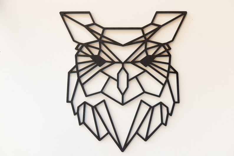 May include: Black geometric owl wall art made of wood. The owl is designed in a modern, minimalist style with a geometric pattern.