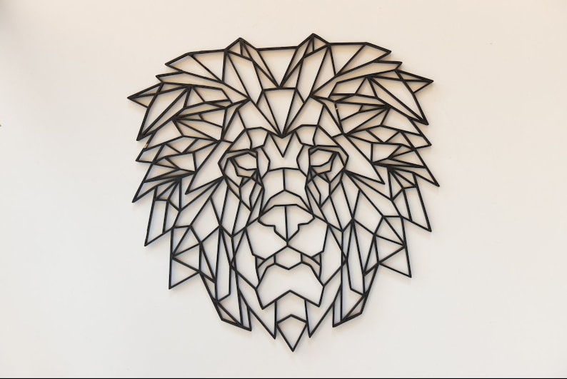 May include: Black geometric lion head wall decor. The lion's mane and face are made up of intricate black lines forming a geometric pattern.