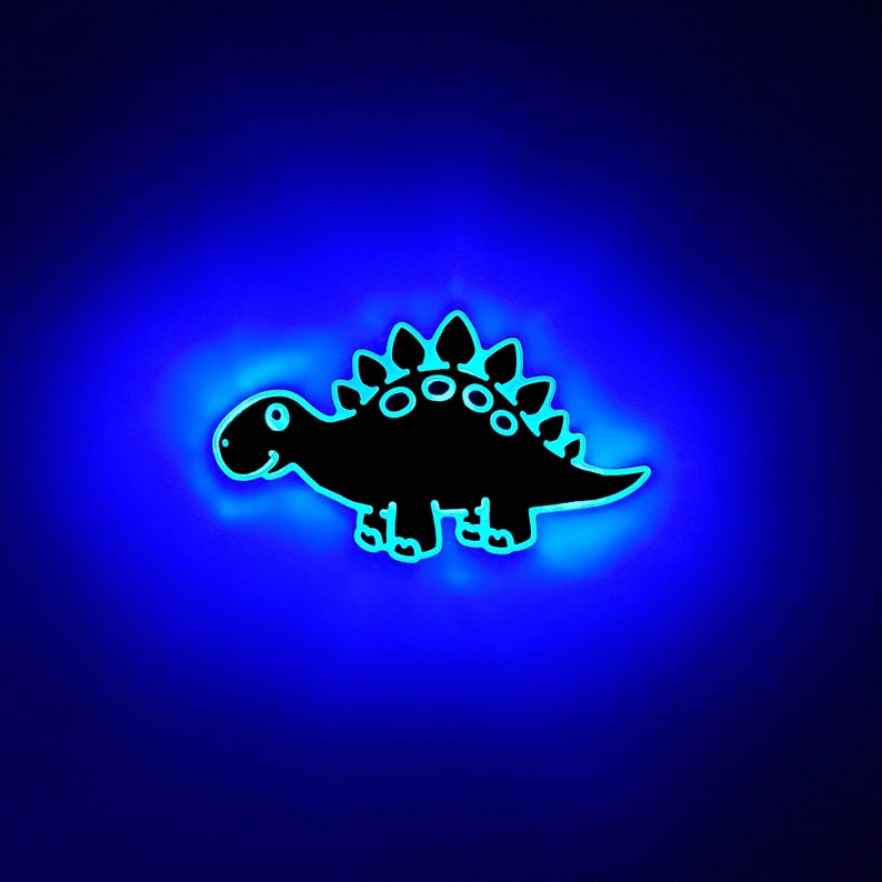 May include: A black silhouette of a cartoon dinosaur with a blue glow around it.