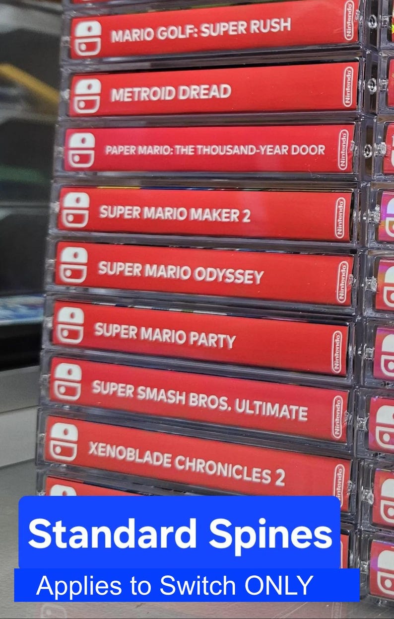 May include: A stack of red Nintendo Switch game cartridges with white text and logos. The games include Mario Golf: Super Rush, Metroid Dread, Paper Mario: The Thousand-Year Door, Super Mario Maker 2, Super Mario Odyssey, Super Mario Party, Super Smash Bros. Ultimate, and Xenoblade Chronicles 2. The text "Standard Spines" and "Applies to Switch ONLY" is at the bottom of the image.