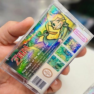 May include: A clear plastic case with a holographic image of Link from The Legend of Zelda: The Minish Cap video game. The back of the case features a description of the game, the Nintendo logo, and a barcode.