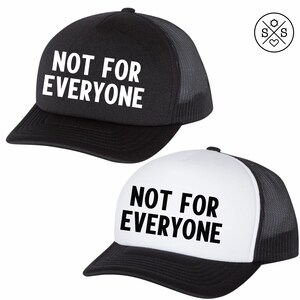 May include: Two black and white trucker hats with a black mesh back. The hats have the text "NOT FOR EVERYONE" printed in white on the front.