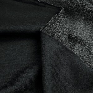 Può includere: Primo piano di due tessuti neri con diverse trame. Un tessuto ha una superficie liscia, mentre l'altro ha una superficie testurizzata.