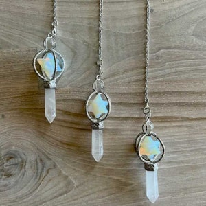 May include: Three silver chain pendulums with clear quartz points and iridescent star-shaped crystal accents.