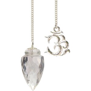 May include: A clear quartz crystal pendulum with a faceted design, suspended by a silver chain. Beside it hangs a silver charm in the shape of the Om symbol, also attached to a silver chain. The background is plain white.