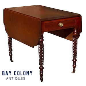 May include: A mahogany drop-leaf table with a single drawer and turned legs. The legs have a woven design and the table has brass hardware.