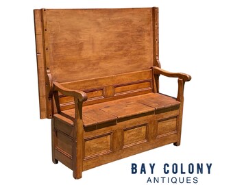 May include: A wooden bench with a high back and a storage compartment. The bench has a hinged top that can be lifted to access the storage space. The bench is made of solid wood and has a natural finish.