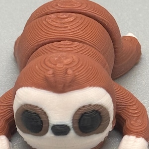 May include: A white ceramic mug with a black handle and the text "But First, Coffee" in a black, handwritten-style font. The mug is on a white surface.