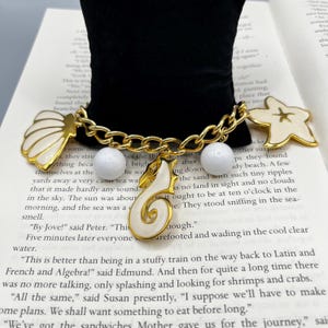 May include: A set of three ceramic mugs with a speckled, matte finish. The mugs are in shades of cream, light gray, and dark gray. Each mug has a simple, minimalist design and a rounded handle.