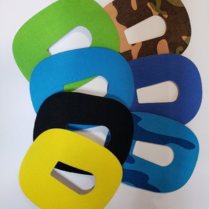 May include: Assortment of six fabric patches in various colors and patterns, including camouflage, blue, green, black, and yellow. Each patch has a hole in the center.