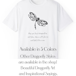 Puede incluir: Camiseta blanca con un gráfico de libélula en blanco y negro y el texto "May you touch dragonflies and stars. dance with fairies and talk to the moon". También se incluye el texto "Available in 5 Colors" y "Other Dragonfly Styles are available in the shop! Beautiful Dragonfly Art and Inspirational Sayings."