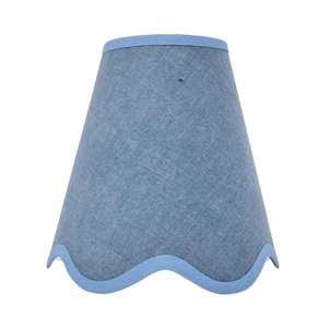 May include: A blue lampshade with a scalloped edge. The lampshade is made of a textured fabric.