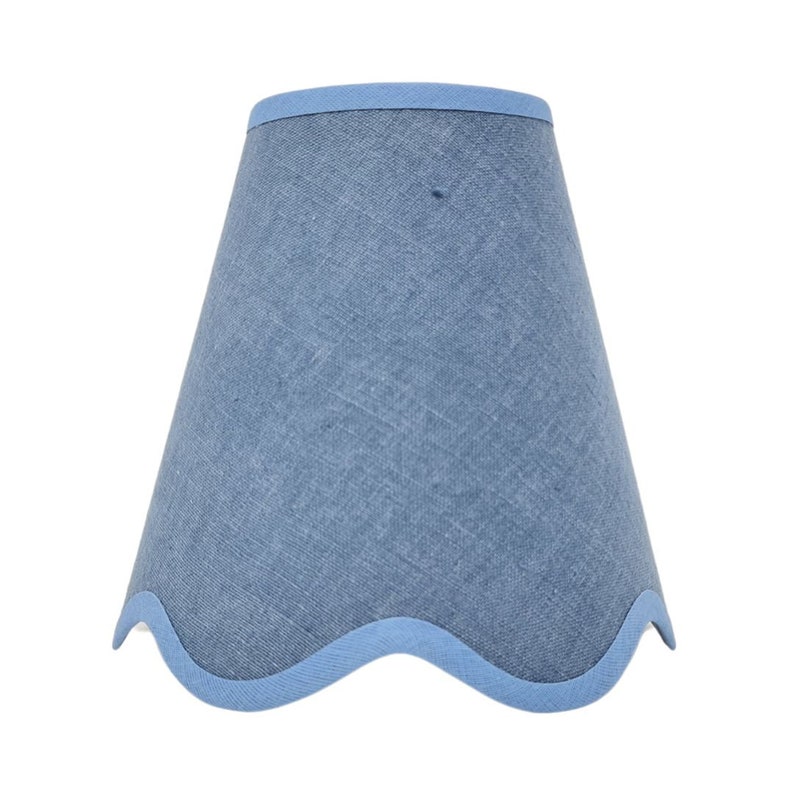 May include: A blue lampshade with a scalloped edge. The lampshade is made of a textured fabric.
