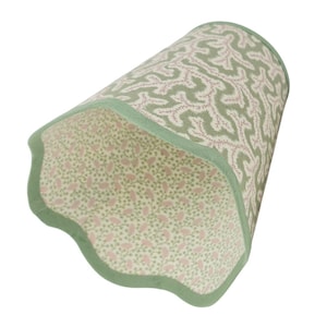Puede incluir: Pantalla de lámpara con borde festoneado, con un patrón verde y blanco en el exterior y un patrón floral rosa en el interior. La pantalla está rematada con un borde verde.