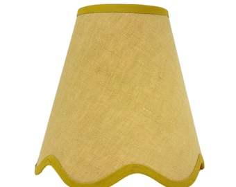 May include: A conical lampshade featuring a textured mustard yellow fabric surface. The top edge is finished with a solid mustard yellow trim, and the bottom edge features a scalloped design also finished with a matching mustard yellow trim.