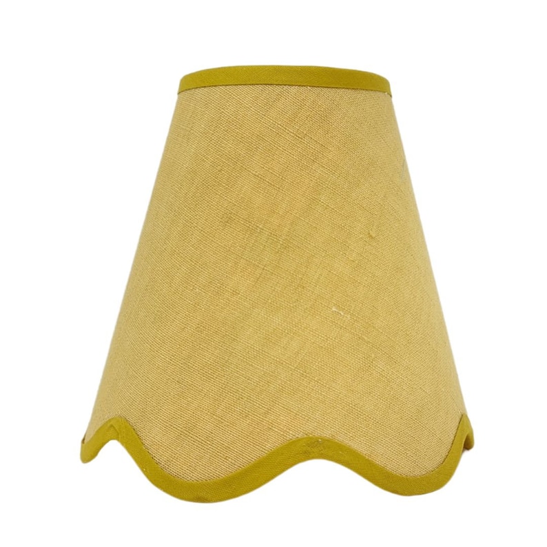 May include: A yellow lampshade with a scalloped edge and a yellow trim.