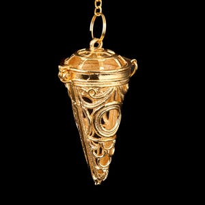 May include: A white ceramic mug with a black handle and the text "But First, Coffee" in a bold, black font. The mug is set against a blurred background, suggesting a cosy setting.