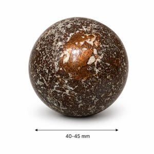 Peut inclure: Une sphère décorative en pierre avec un motif moucheté de tons marron, blanc et cuivré. La sphère mesure 40-45 mm de diamètre. La surface présente un aspect texturé, avec des variations de couleur et de veinage.