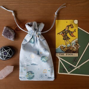 Vågens tarotkortspåse med dragsko, runstenar, orakelkort, kristaller, påse, grått astrologiskt zodiakmönster i tyg/satinfoder