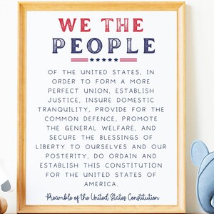 May include: A framed print featuring the text "We the People" in red and blue lettering. The text is from the Preamble of the United States Constitution.