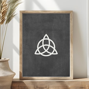 Puede incluir: Una impresión en blanco y negro de un símbolo triquetra, un nudo celta, en un marco de madera. La impresión tiene un fondo texturizado.