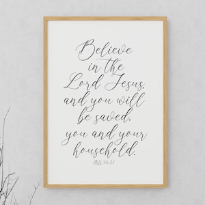 May include: A white framed print with a black calligraphy quote that reads "Believe in the Lord Jesus and you will be saved, you and your household. Acts 16:31".