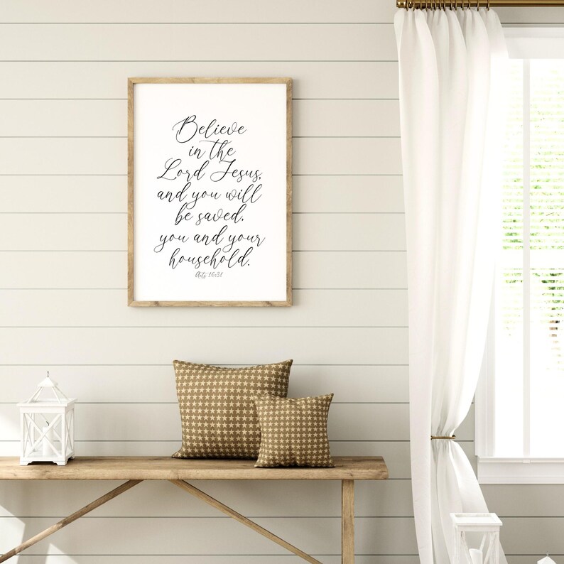 May include: A framed print with a white background and black text that reads "Believe in the Lord Jesus and you will be saved. You and your household. Acts 16:31".