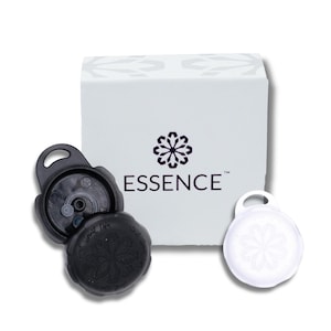 May include: Two round black and white bottle stoppers with a flower design. The stoppers are labeled "Essence" and have a small hole in the center. The stoppers are packaged in a white box with a flower design.