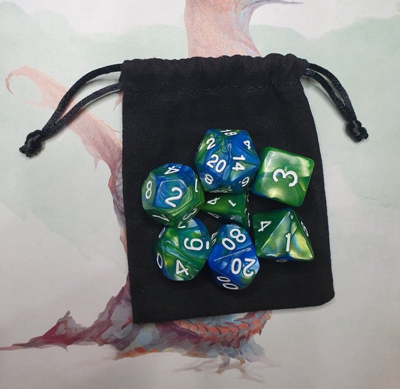 May include: A set of seven green and blue dice with white numbers. The dice are in a black velvet drawstring bag.
