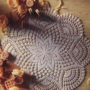 May include: A white crocheted doily with a delicate floral pattern. The doily is surrounded by cookies, pasta, and other food items.