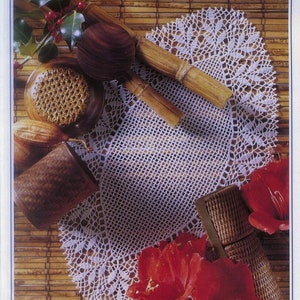 Puede incluir: Una naturaleza muerta con un tapete de encaje blanco, cucharas de servir de madera y cestas tejidas. La escena se acentúa con flores de amarilis rojas y ramitas de acebo. Los objetos están dispuestos sobre una estera de bambú.