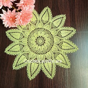Puede incluir: Un mantel individual de ganchillo de color verde lima con un diseño de estrella. El mantel individual está hecho con delicados puntos de ganchillo y tiene un aspecto de encaje.