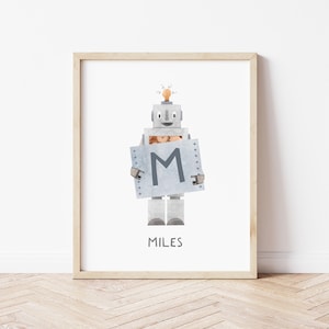 Könnte beinhalten: Ein gerahmter Druck mit einem Roboter, der ein Schild mit dem Buchstaben "M" und dem Namen "Miles" darunter hält. Der Roboter ist grau und hat eine Glühbirne auf dem Kopf.