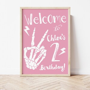 Puede incluir: Se&ntilde;al imprimible rosa con una mano de esqueleto blanca haciendo un signo de paz, rayos y el texto "&iexcl;Bienvenido al 2&ordm; cumplea&ntilde;os de Chloe!"