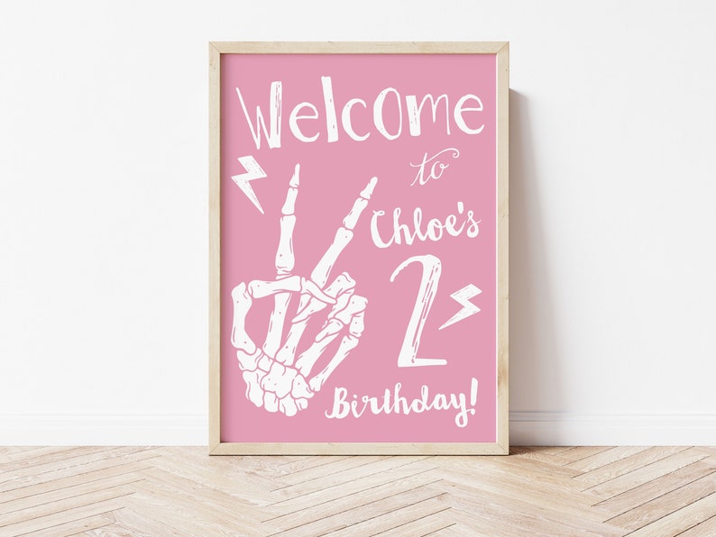 Puede incluir: Se&ntilde;al imprimible rosa con una mano de esqueleto blanca haciendo un signo de paz, rayos y el texto "&iexcl;Bienvenido al 2&ordm; cumplea&ntilde;os de Chloe!"