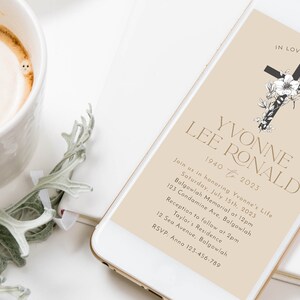 May include: A smartphone displays a memorial invitation with the text "In Loving Memory" and the name "Yvonne Lee Ronald." The invitation includes event details, a cross graphic, and floral accents. A cup of coffee and a sprig of greenery are in the background.