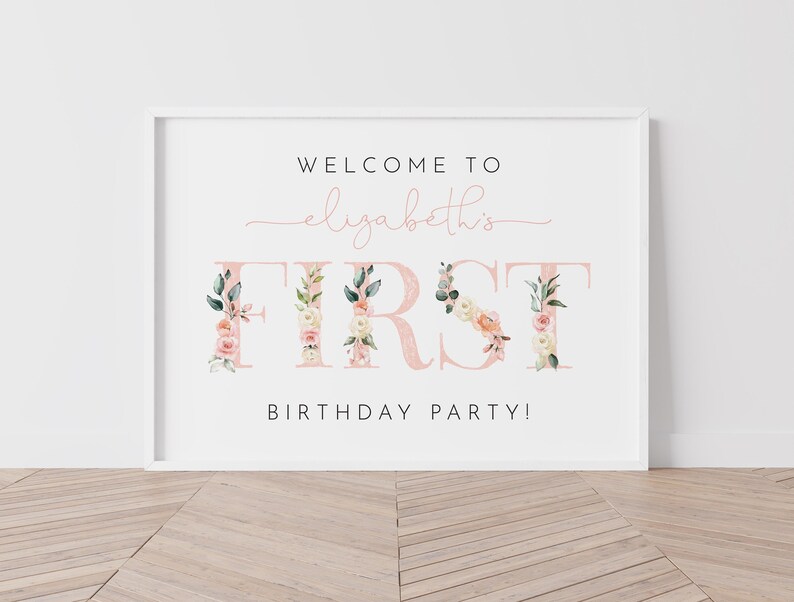 Pu&ograve; includere: Un cartello bianco con un design floreale rosa che dice "Benvenuti al primo compleanno di Elizabeth!"