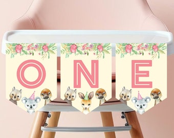 May include: A pink and yellow banner with the word "ONE" in pink letters. The banner is decorated with floral designs and cute animal illustrations, including a koala, a kangaroo, and a platypus.