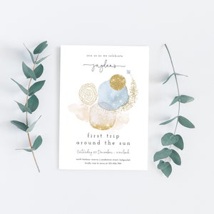 May include: A white invitation card with a blue and gold watercolor design. The text on the card reads "Join us as we celebrate Jayden's first trip around the sun. Saturday 23 December -  [location] North Harbour Avenue, Condamine Street, [location]  RSVP to [phone number] by [date]"