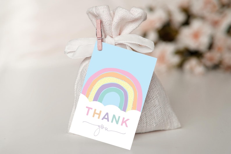 May include: A pastel rainbow with a cloud and the text "THANK you" on a light blue background. This is a thank you tag for a party favor.