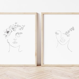 May include: Two minimalist line art prints of a face with floral details. The first print features a face with flowers around the forehead. The second print features a face with flowers around one eye.