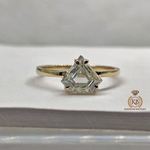 Peut inclure: Une bague en or avec un diamant de forme triangulaire.