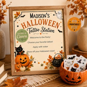 May include: A framed sign titled Madison's Halloween Tattoo Station with instructions for a party. The sign features illustrations of a black cat, pumpkins, a ghost, and autumn leaves. Beside it sits an orange pumpkin-shaped bowl filled with temporary tattoos.